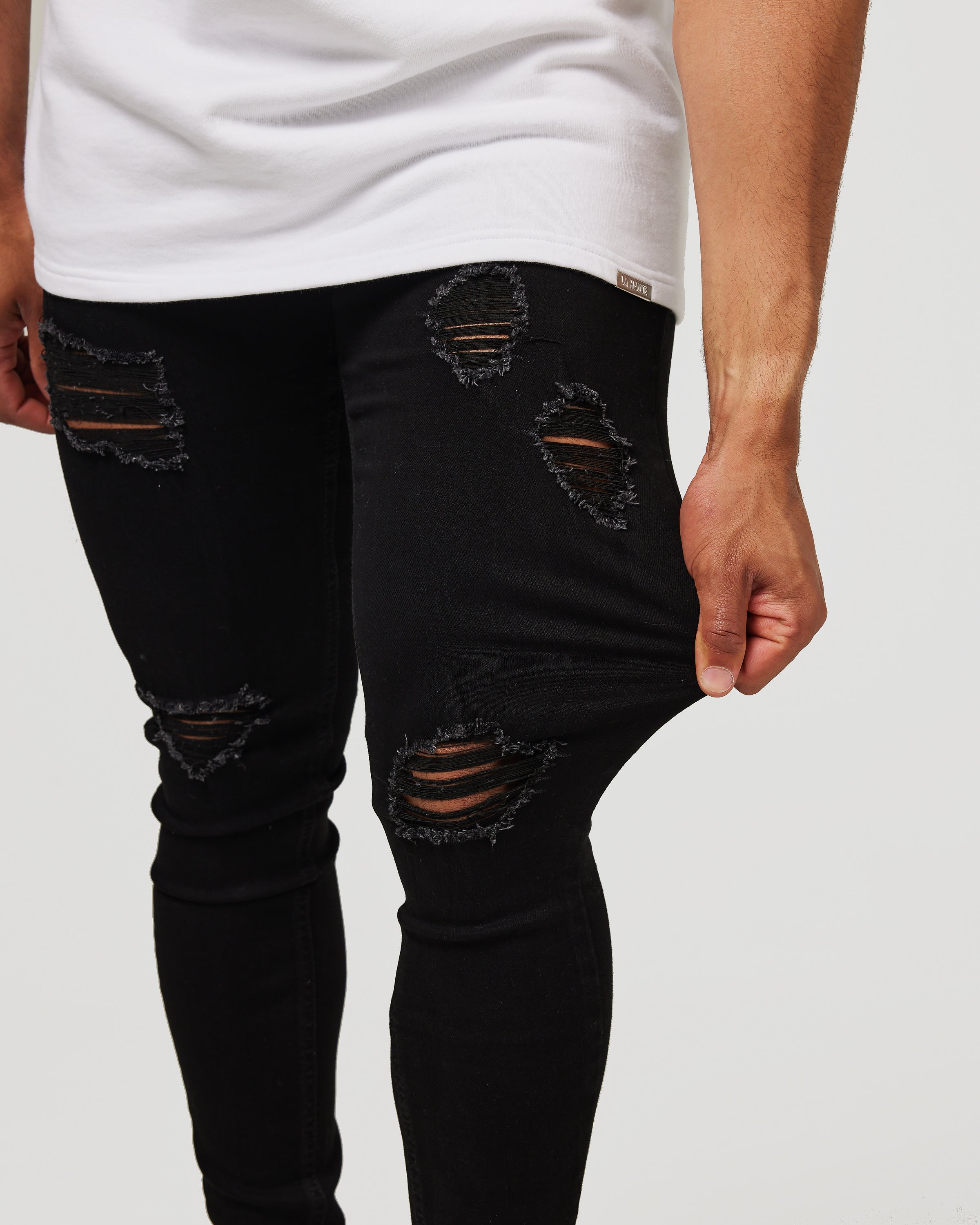 Jeans skinny noirs déchirés - denim usé et audacieux avec coupe slim